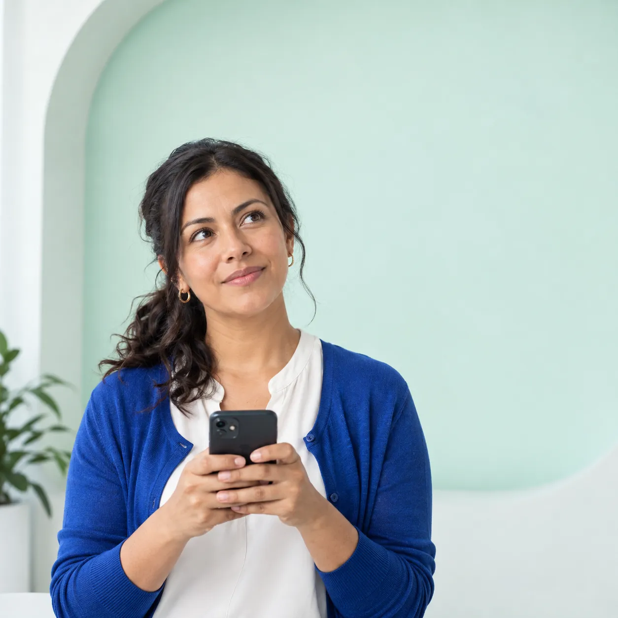 Mujer sostiene su celular con gesto pensativo