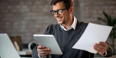 Hombre revisando documentos financieros en una tablet