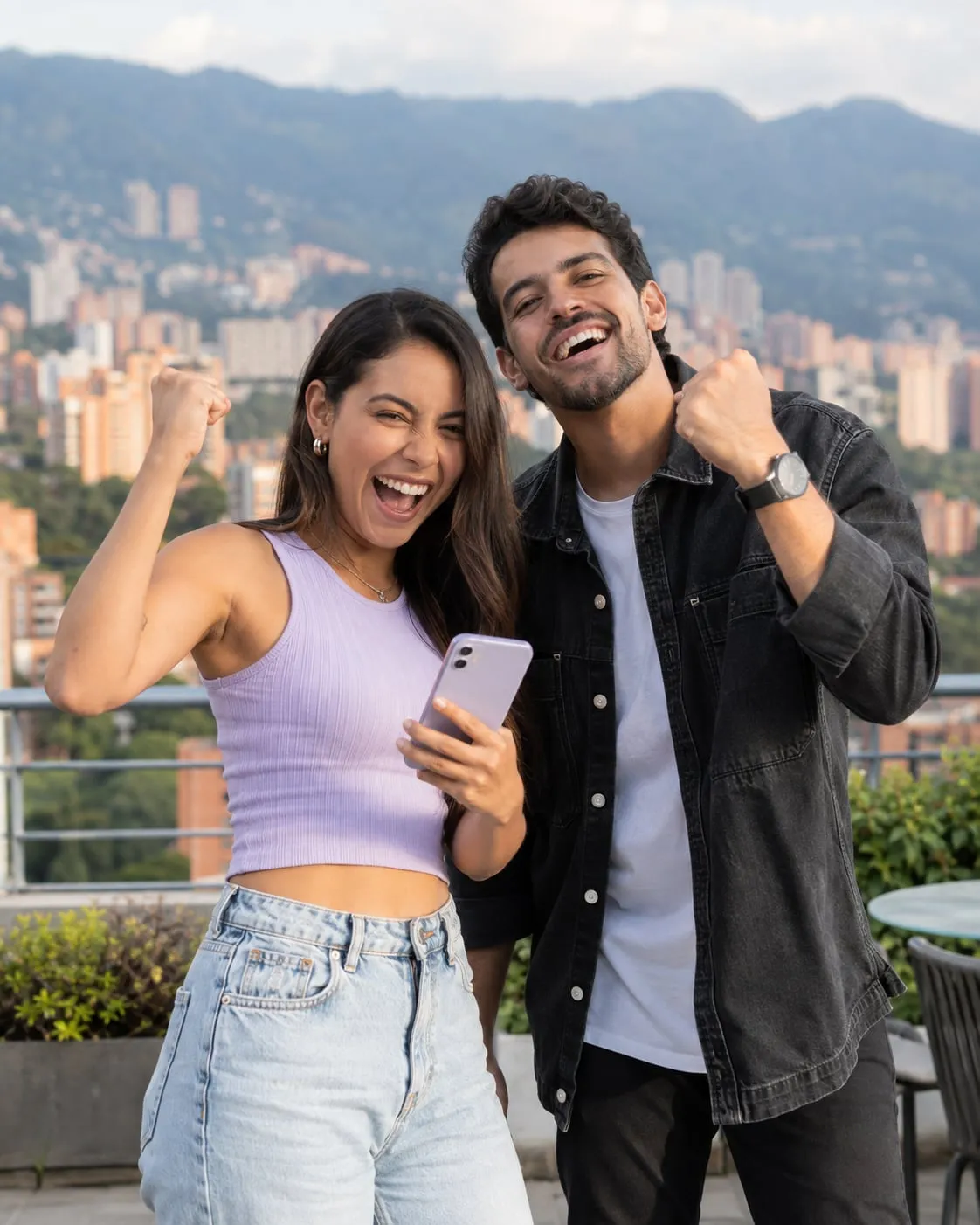 Pareja de jóvenes colombianos celebrando con un celular