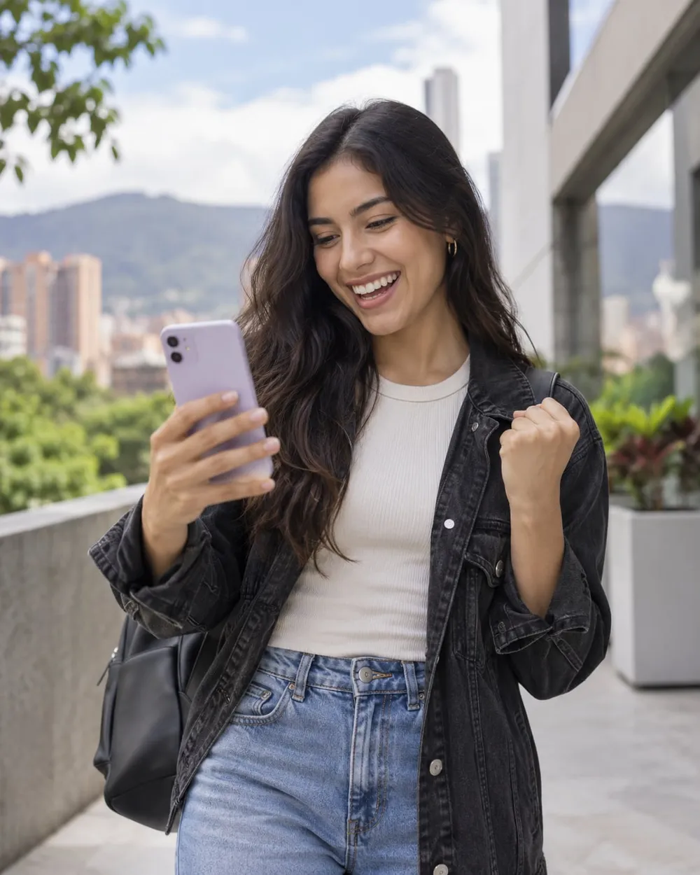Joven colombiana celebrando buenas noticias en su celular