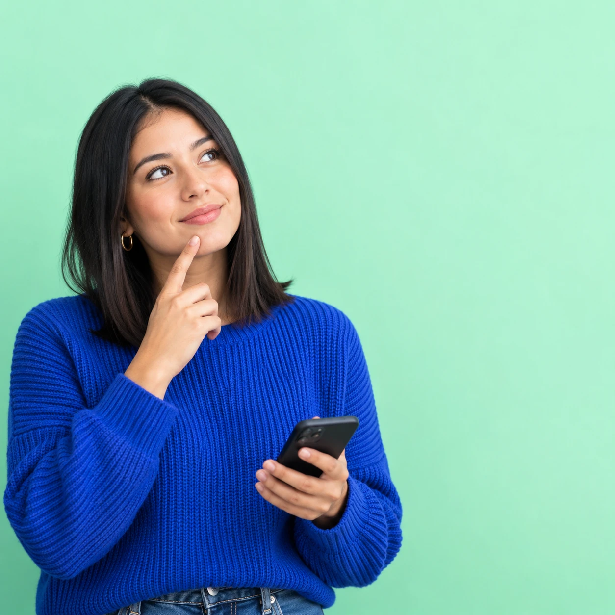 Mujer pensativa con su celular en la mano