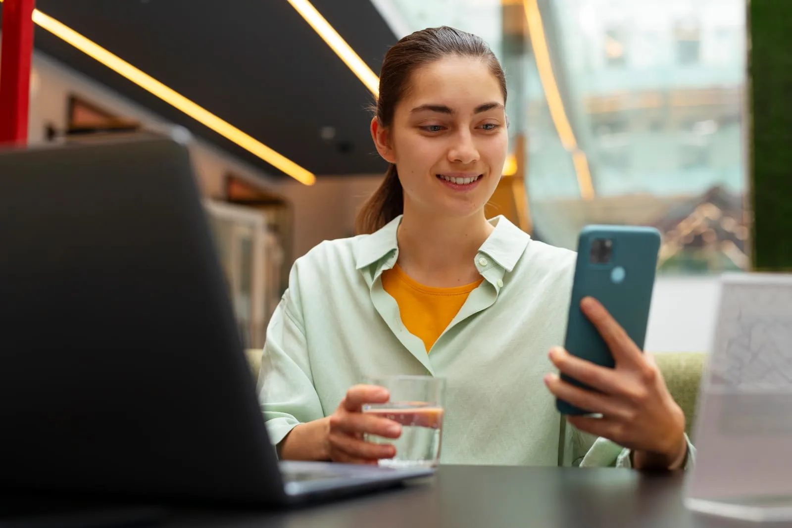 Mujer sonriente simulando su préstamo en el celular